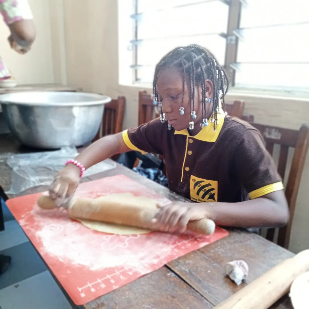 A girl rolling out dough during a cooking class