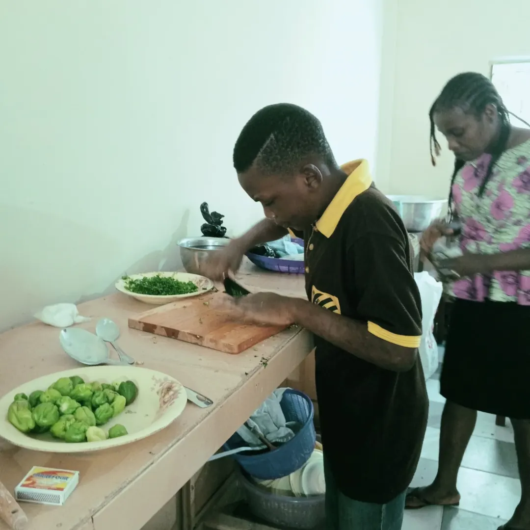 A pupil chopping vegetables in a cooking activity
